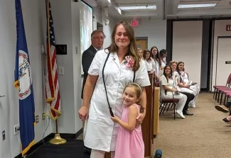 A student standing with her daughter